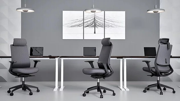 Tapicerowane krzesła obrotowe zostały ustawione na tle czarnej ściany. Jedno zaprezentowane jest z przodu, drugie - z tyłu.